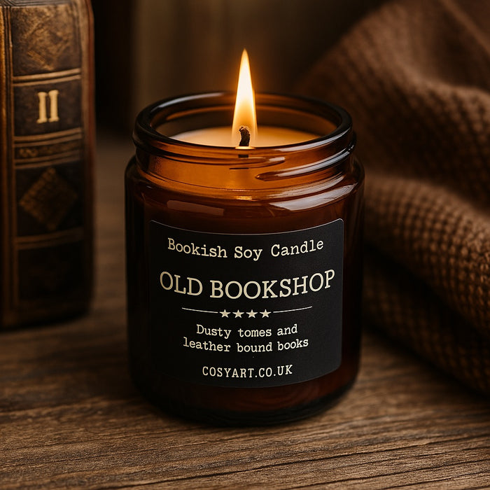 Old Bookshop candle by Cosy Art London styled on wood slice with glowing flame, surrounded by vintage books and warm autumn tones. Handmade in London.